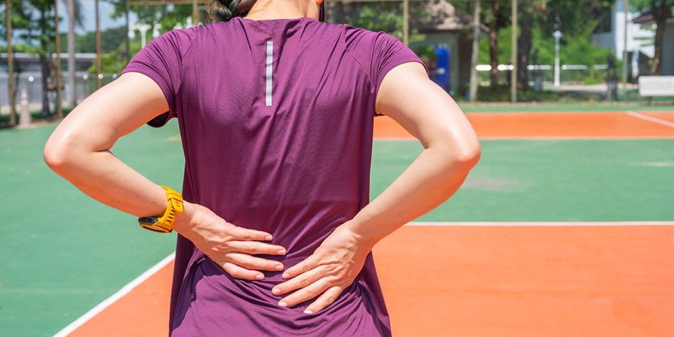 Woman placing hands on back due to lower back pain