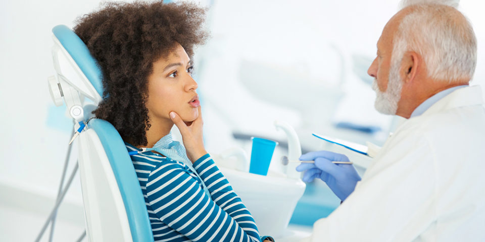 A woman speaks with her dentist about jaw pain